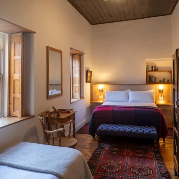 The Courtyard Room at 81 On Church, with a single bed, desk and rugs